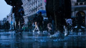 Des piétons traversent une rue inondée suite à de fortes pluies, à Paris, le 17 octobre 2024. (photo d'illustration)