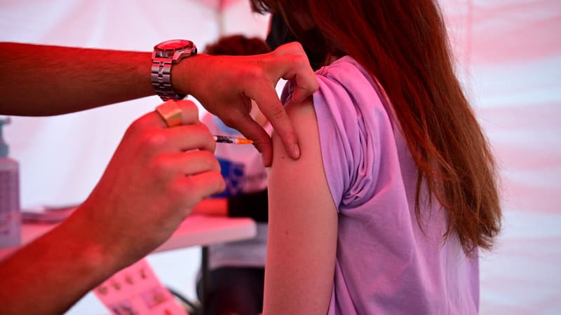 Une jeune femme se fait vacciner. 