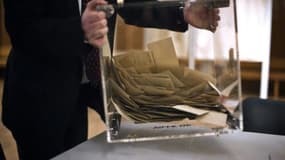 Un scrutateur vide l'urne contenant les bulletins de vote, le 20 mars 2011 à Dijon