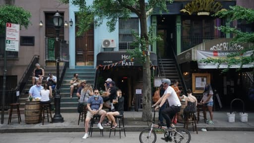 Des habitants en terrasse devant un bar à New York le 7 juin 2020