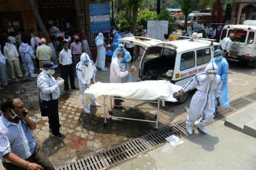 Le corps d'une victime du coronavirus est sorti d'une ambulance pour être incinéré au crématorium du site de Nigambodh Ghat, le 3 juin 2020 à New Delhi Le corps d'une victime du coronavirus est sorti d'une ambulance pour être incinéré au crématorium du site de Nigambodh Ghat, le 3 juin 2020 à New Delhi