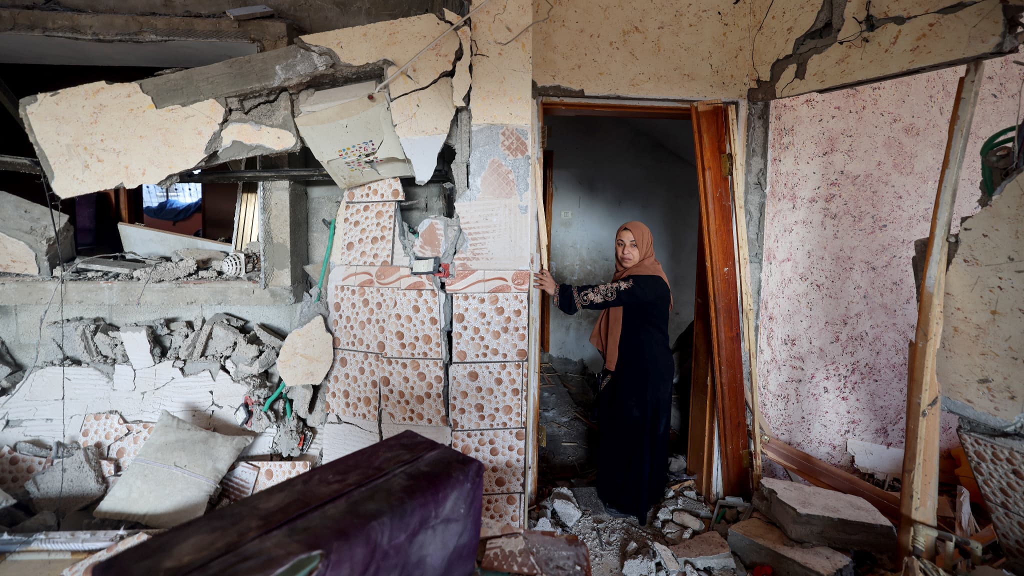 Une femme constate les dégâts d'une frappe israélienne sur sa maison à Rafah, dans la bande de Gaza, le 5 janvier 2024