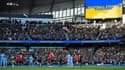 Les joueurs de Manchester City et de Manchester United participent à une minute d'applaudissements à l'unisson avec les spectateurs, en soutien de l'Ukraine, suite à l'invasion russe, avant leur derby de la 28e journée de Premier League, le 6 mars 2022 à l'Etihad Stadium.