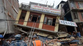 Des secours regardent un immeuble sérieusement endommagé par le séisme, le 26 avril, à Katmandou, au Népal. 