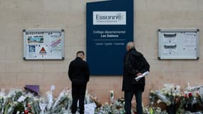 Des habitants regardent les fleurs déposées devant le collège des Sablons à Viry-Châtillon, en Essonne, le 7 avril 2024