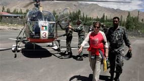 Un militaire indien aide une touriste espagnole à sa descente d'hélicoptère après avoir été secourue dans les environs de Leh, dans la région himalayenne du Ladakh. Trois jours après de brusques inondations qui ont fait au moins 150 morts en Inde et ravag