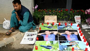 Un Afghan assis à côté de portraits de Quayyeem Ahmadzai, tué par balle dimanche dans une altercation, le 17 août 2022 à Colmar