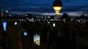 Des visiteurs photographient la vasque olympique accrochée à un ballon, le 6 août 2024 à Paris