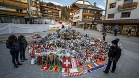 Des fleurs, des messages et des drapeaux déposés sur un mémorial improvisé le 6 janvier 2026 en hommage aux victimes de l'incendie mortel d'un bar dans la nuit du nouvel an à Crans-Montana, en Suisse