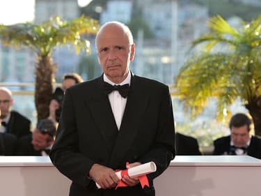 Le producteur français Alain Sarde pose avec le Prix du jury qu'il a accepté au nom du réalisateur franco-suisse Jean-Luc Godard lors d'un photocall après la cérémonie de clôture de la 67e édition du Festival de Cannes, dans le sud de la France, le 24 mai 2014. 
