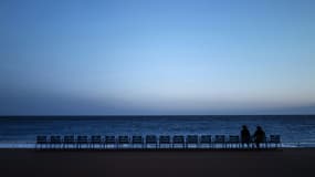 Deux personnes goûtent l'air du soir sur la Promenade des Anglais, à Nice le 21 février 2021