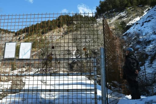 Un homme regarde à travers les barrières "sanctuarisant" le site du crash près du Vernet (Alpes-de-Haute-Provence), le 18 mars 2016 Un homme regarde à travers les barrières "sanctuarisant" le site du crash près du Vernet (Alpes-de-Haute-Provence), le 18 mars 2016