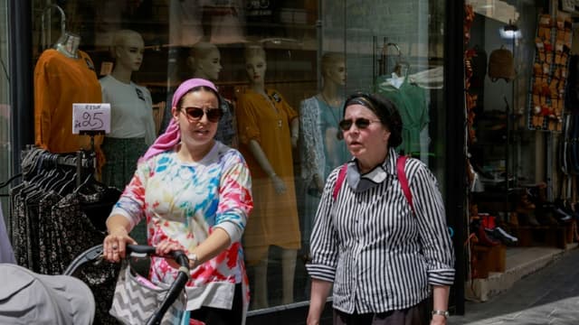 Des femmes sans masques sanitaires dans un marché de Jérusalem, le 18 avril 2021, après la levée de l'obligation de port du masque en Israël (photo d'illustration)