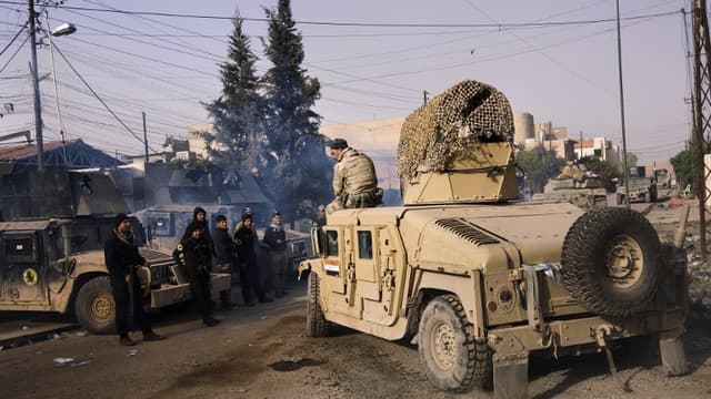 Un soldat irakien assit sur un Humvee, et des membres des services antiterroristes irakiens à l'est de Mossoul le 10 janvier 2017 (image d'illustration)