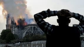 Un passant regarde Notre-Dame en flammes le 15 avril 2019