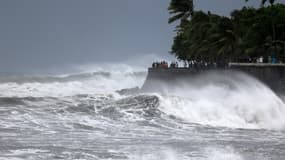 Des promeneurs observent la mer au bord de la plage de Saint-Benoît, à l'approche du cyclone Emnati, le 20 février 2022 (illustration). 