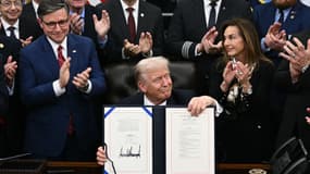 Le président américain Donald Trump (au centre) présente le projet de loi signé visant à rouvrir le gouvernement fédéral, sous les applaudissements du président de la Chambre des représentants, Mike Johnson (à gauche), et d'autres dirigeants républicains, dans le Bureau ovale de la Maison-Blanche à Washington, le 12 novembre 2025.