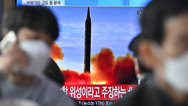Des personnes sont assises près d'une télévision diffusant un journal télévisé avec des images d'archives d'un test de missile nord-coréen, dans une gare de Séoul, le 24 mars 2022. La Corée du Nord a tiré un missile balistique intercontinental (ICBM) le 24 mars, a déclaré le président sud-coréen Moon Jae-in, la première fois que Pyongyang lance une arme aussi puissante depuis 2017.