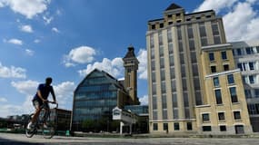 Un cycliste devant les Grands Moulins de Pantin, transformés en bureaux, qui bordent le canal de l'Ourcq, le 30 juillet 2022 (photo d'illustration)