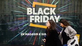 Des passantes marchent devant un panneau annonçant le "Black Friday" à Paris le 23 novembre 2018