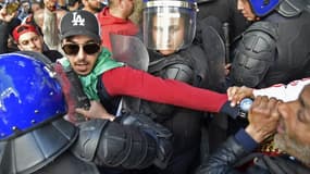 Un manifestant algérien entre les forces de l'ordre, ce vendredi, lors de la manifestation contre la réélection d'Abdelaziz Bouteflika.