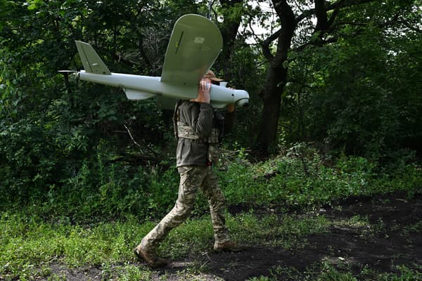 Un militaire ukrainien d transporte un drone de reconnaissance Leleka après son atterrissage sur une position dans la région de Donetsk, le 27 juin 2023