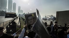Des supporters de l'ancien président égyptien Hosni Moubarak. En arrière-plan, l'hélicoptère transportant Moubarak de l'hôpital, pour assister au verdict de son procès.