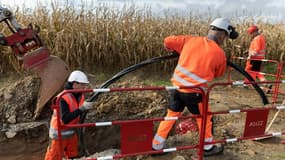 Des sous-traitants d'Enedis réalisent des travaux de terrassement pour créer une boîte de jonction entre deux réseaux de câbles souterrains, à Ergue-Gaberic, dans le Finistère, le 28 octobre 2024