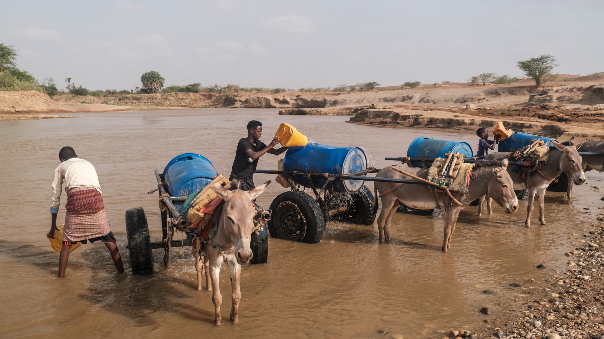 Des personnes remplissent des réservoirs d'eau dans la rivière Shabelle dans la ville de Gode, en Éthiopie, le 8 avril 2022, alors que la pire sécheresse des quarante dernières années frappe la Corne de l'Afrique.
