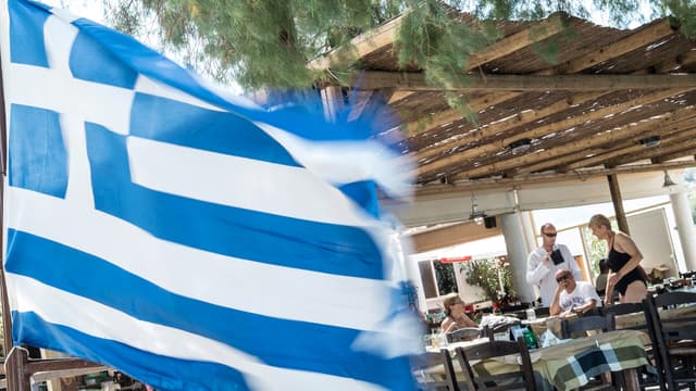 Drapeau grec flottant à la terrasse d'un restaurant, le 12 juillet sur l'île de Salamina, près d'Athènes.