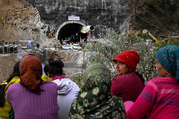 Des villageois et des habitants se rassemblent pour observer les efforts déployés par les secouristes pour sauver les 41 hommes coincés dans le tunnel Silkyara en construction qui s'est effondré dans le district d'Uttarkashi, dans l'État indien de l'Uttarakhand, le 28 novembre 2023. 
