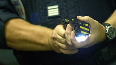 Un policier teste le 15 septembre 2004 à l'hôtel de police de Lyon un pistolet paralysant. Photo d'illustration.
