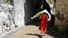 Une femme se protège du soleil avec un foulard, le 17 juillet 2023 à Avignon, lors d'une vague de chaleur en France