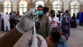Un soignant s'apprête à administrer un vaccin anti-Covid à un homme dans un centre de vaccination à Karachi en Inde le 5 mai 2021
