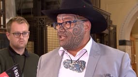 Le co-chef du parti maori néo-zélandais Rawiri Waititi s'adresse aux médias à Wellington après avoir été expulsé du parlement pour avoir refusé de porter une cravate, portant à la place un hei-tiki, un pendentif traditionnel de pierres précieuses, le 9 février 2021.