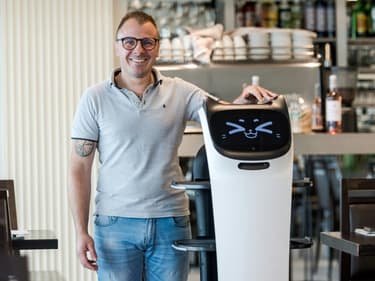 Geoffrey Ruamps, directeur du restaurant le Cap 180, pose avec le robot serveur "Bella" dans son restaurant, à Cieurac, dans le Lot, le 14 mai 2024.