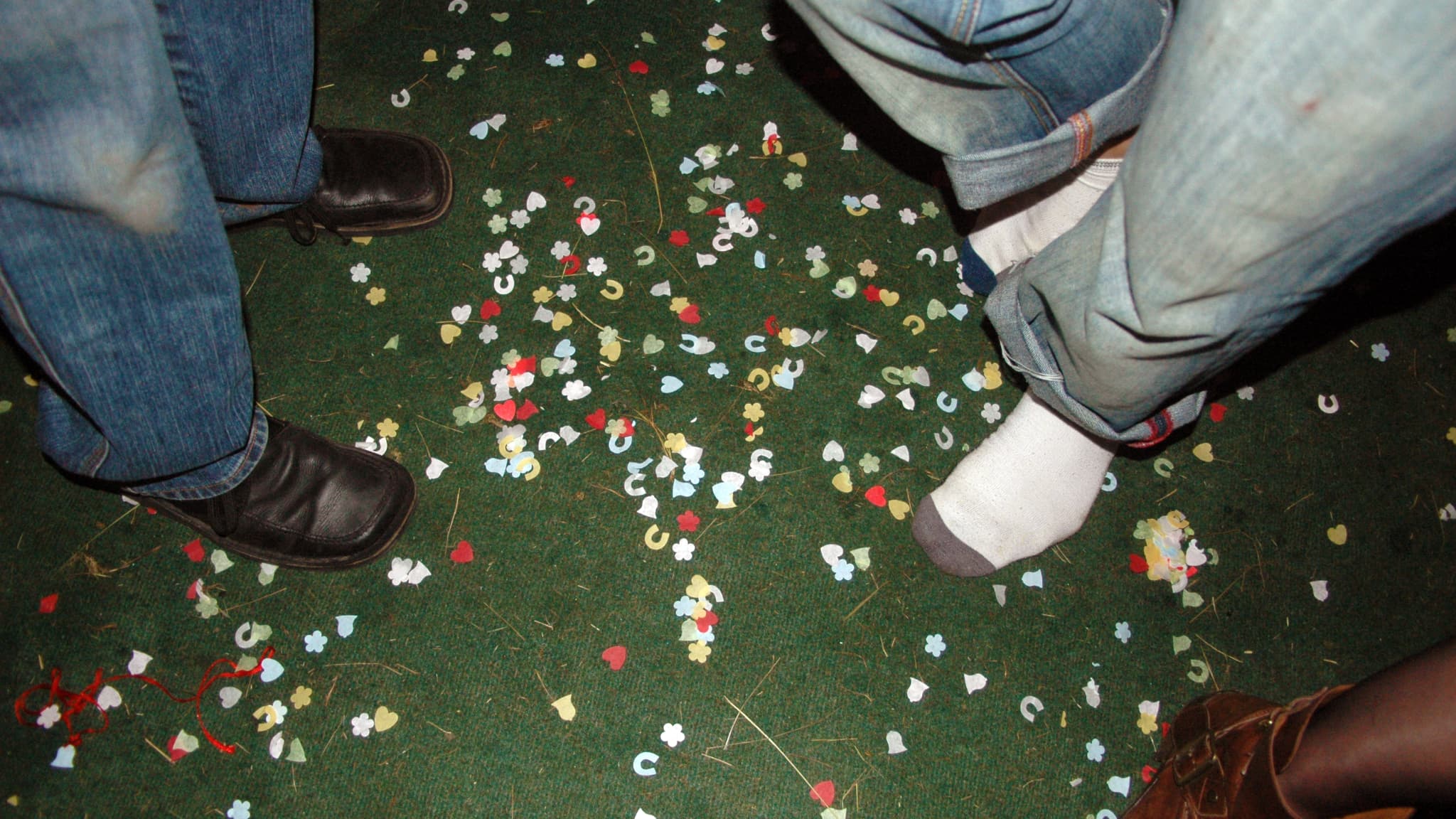Des personnes en train de faire la fête, su run sol couvert de confettis.