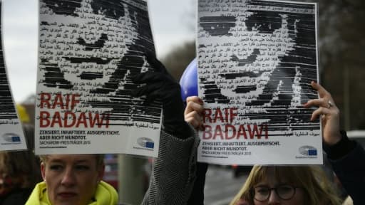 Des membres de l'ONG Amnesty International brandissent des portraits du blogueur saoudien Raef Badawi lors d'une manifestation devant l'ambassade d'Arabie saoudite à Berlin, le 8 janvier 2016.
