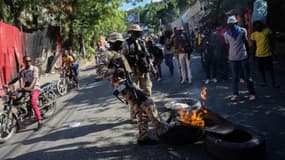 Des policiers éteignent des feux de barricades allumés par des manifestants contestant la hausse du prix de l'essence à Port-au-Prince, Haiti, le 10 décembre 2021