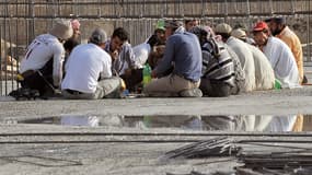 Des travailleurs étrangers d'Arabie saoudite prennent un repas.