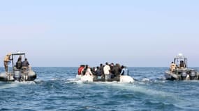 Des gardes-côtes libyens escortent une embarcation transportant des migrants qui espéraient se rendre en Europe depuis la ville libyenne côtière de Garabulli, le 6 juin 2015 au large de Tripoli