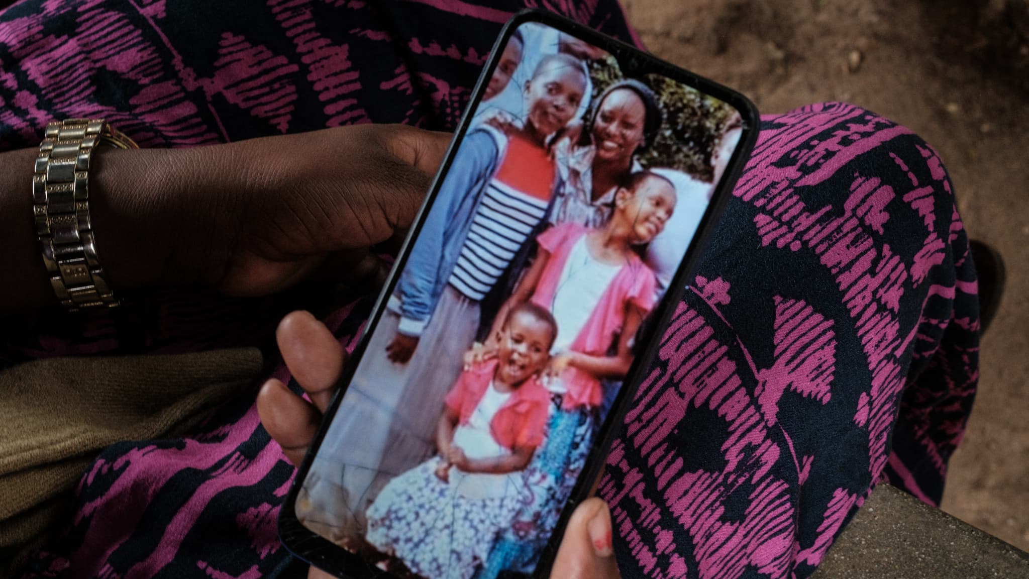Bethy Kahindi, 37 ans, montre une photo sur son téléphone de trois des six filles de sa sœur de 45 ans alors qu'elle cherche leurs corps à la morgue de l'hôpital de Malindi Sub-County à Malindi, le 26 avril 2023.
