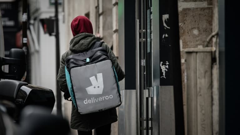 Un livreur pour la plateforme Deliveroo cherche une adresse à Paris, le 8 mars 2020