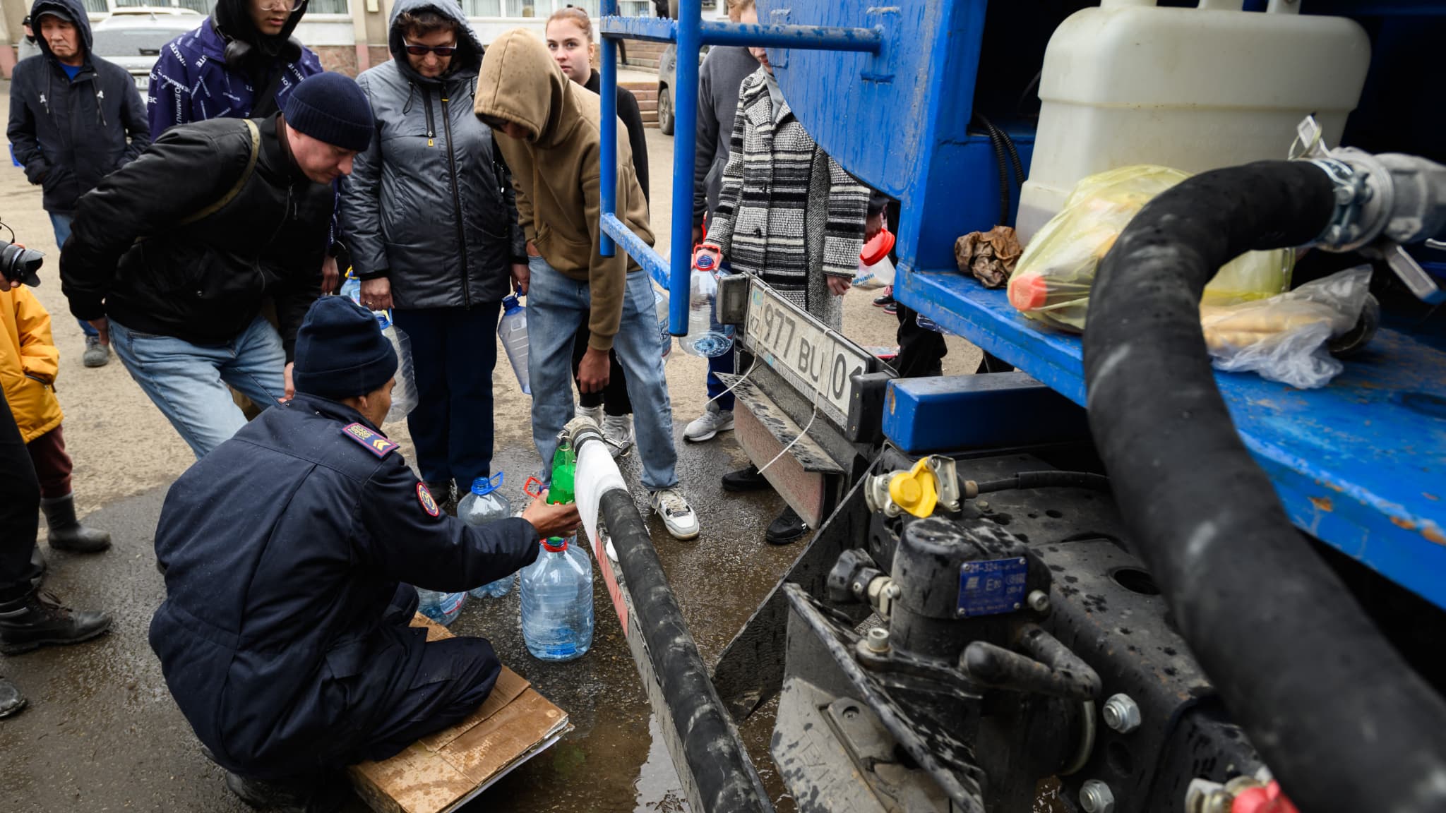 Des habitants font la queue pour obtenir de l'eau potable dans la ville de Petropavl, touchée par les inondations, dans le nord du Kazakhstan, près de la frontière avec la Russie, le 14 avril 2024.