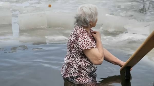 Valentyna, 86, dives into the water of the Donets, January 19, 2023 