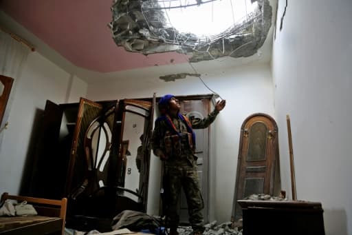 Un combattant des Forces démocratiques syriennes (FDS), regarde les dégâts dans le toit d'une maison, dans un quartier de l'Est de Raqa, lors d'une offensive contre l'EI, le 14 juin 2017 Un combattant des Forces démocratiques syriennes (FDS), regarde les dégâts dans le toit d'une maison, dans un quartier de l'Est de Raqa, lors d'une offensive contre l'EI, le 14 juin 2017