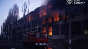Un camion de pompiers est garé à côté d'un bâtiment en feu à la suite d'une attaque aérienne dans un lieu non divulgué de la région d'Odessa, le 13 décembre 2025