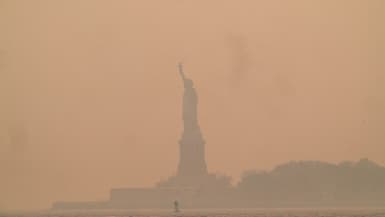 La Statue de la Liberté à Upper Bay est enveloppée d'une brume de fumée provenant des incendies de forêt au Canada, le 7 juin 2023 à New York.