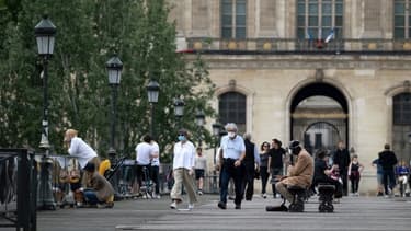 Des personnes masquées en train de marche sur le pont des Arts à Paris, le 9 mai 2020.