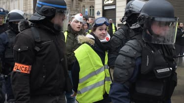 Une manifestante arborant un gilet jaune, interpellée samedi matin, sur les Champs Elysées.